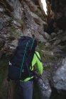 Крупный план восхождения туриста на холм с рюкзаком — стоковое фото