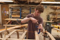Молодой плотник работает в мастерской — стоковое фото