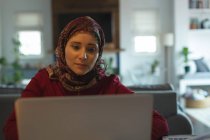 Мусульманську жінку, використовуючи ноутбук на дому — стокове фото