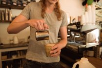 Mid section of barista making coffee at cafeteria counter — Stock Photo