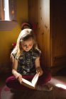 Young girl reading book in bedroom at home — Stock Photo
