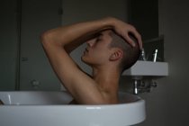 Depressiver junger Mann sitzt in Badewanne im Badezimmer — Stockfoto