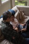 Pai e filho usando tablet digital na sala de estar em casa — Fotografia de Stock