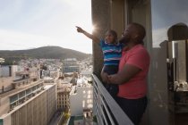 Vater trägt Sohn auf Balkon zu Hause. — Stockfoto