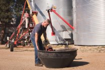Mann raffiniert Getreide in Container in Fabrik — Stockfoto