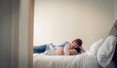Mother playing with her baby girl in bedroom at home — Stock Photo