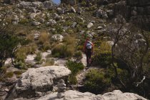 Escursionista arrampicata in collina con zaino in una giornata di sole — Foto stock