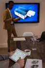 Exécutif utilisant une tablette numérique pendant la présentation dans la salle de réunion au bureau créatif — Photo de stock