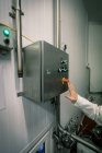 Trabajador presionando el interruptor de control en la fábrica de alimentos - foto de stock