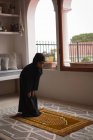 Chica musulmana rezando salah en casa - foto de stock