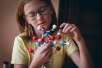 Дівчина в окулярах експериментує з молекулою вдома — стокове фото