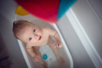 Bebê menina tomando banho na banheira no banheiro — Fotografia de Stock
