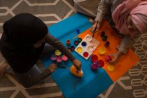 Мусульманская девушка и ее мать рисуют акварелью дома — стоковое фото