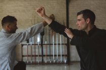 Combattants de kung fu pratiquant les arts martiaux en studio de fitness . — Photo de stock