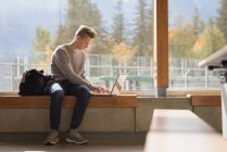 Menino adolescente usando laptop na universidade — Fotografia de Stock