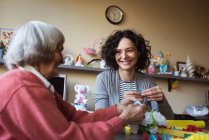 Sorridente donna anziana che interagisce con il custode della casa di cura — Foto stock