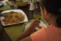 Mädchen frühstückt zu Hause am Esstisch — Stockfoto