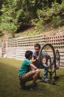 Father and son interacting with each other while repairing cycle in the garden — Stock Photo