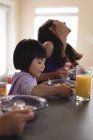 Счастливые братья и сестры завтракают за столом на кухне — стоковое фото