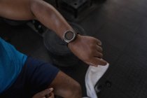 Nahaufnahme einer Smartwatch am Handgelenk eines Mannes im Fitnessstudio. — Stockfoto