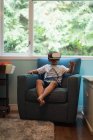 Boy using virtual reality headset in living room at home — Stock Photo