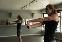 Человек практикующий упражнения на растяжку в фитнес-студии . — стоковое фото