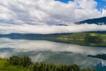 Schöne Aussicht auf weiße Wolken, die sich im Fluss inmitten grüner Landschaft spiegeln — Stockfoto