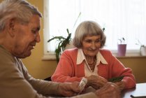 Seniorenfreunde spielen Karten im Pflegezimmer — Stockfoto