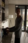 Young man using coffeemaker machine at home — Stock Photo
