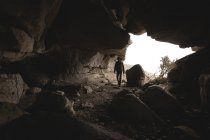 Caminhante entrando dentro da caverna na hora do dia — Fotografia de Stock