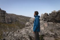 Vue latérale du randonneur debout sur une montagne rocheuse — Photo de stock