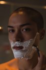 Young man shaving his beard in bathroom — Stock Photo