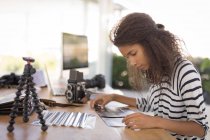 Beautiful photographer working at desk in the photo studio — Stock Photo
