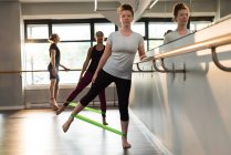 Women and man exercising with resistance bands in fitness studio. — Stock Photo