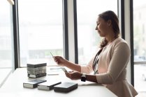 Female executive examining slabs at desk in office — Stock Photo
