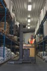 Mann hebt Getreidesack mit Gabelstapler in Fabrik — Stockfoto