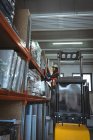 Arbeiterin fährt Gabelstapler in Lagerhalle — Stockfoto