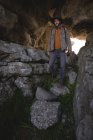 Randonneur marchant sur les rochers dans la grotte — Photo de stock