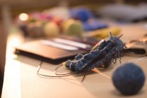 Primo piano lana lavorata a maglia su un tavolo in sartoria — Foto stock