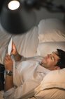 Uomo d'affari che utilizza tablet digitale in camera da letto in hotel — Foto stock