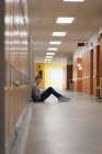 Teenage boy sitting in locker room at university — Stock Photo