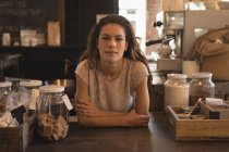 Portrait of waitress standing at counter in the coffee shop — Stock Photo
