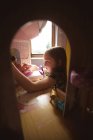 Menina brincando com casa de bonecas no quarto em casa — Fotografia de Stock
