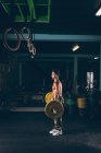 Мускулистый мужчина тренируется с штангой в фитнес-студии — стоковое фото