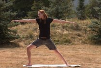 In forma uomo che esegue esercizio di stretching su un terreno aperto una giornata di sole — Foto stock