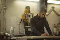 Männliche Arbeiter markieren mit Bleistift in der Fabrik — Stockfoto