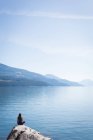 Woman practicing yoga on rock near sea side — Stock Photo