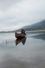 Man oaring canoe in silent river — Stock Photo