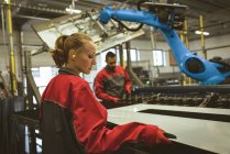 Travailleur féminin vérifiant une feuille de verre dans l'usine — Photo de stock