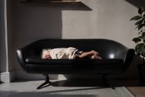 Menina da criança dormindo no sofá na sala de estar em casa . — Fotografia de Stock